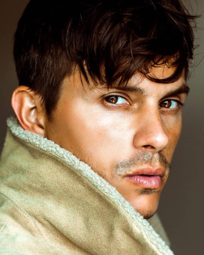 Kenny Braasch modeling a light-brown shearling coat.